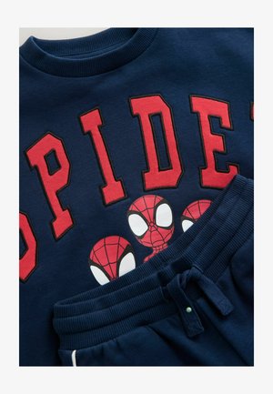 Sudadera navy con la inscripción roja "SPIDER", que presenta tres diseños de Spider-Man. Combinada con pantalones de chándal navy, con cinturilla elástica y cordón.
