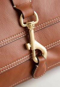 Borsa in pelle marrone con una chiusura metallica dorata, cuciture a contrasto e una superficie liscia con un attacco per la tracolla robusto.