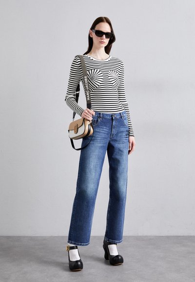 Striped long-sleeve top, blue jeans, black platform shoes, and a color-blocked shoulder bag. Smooth textures and casual fit overall.