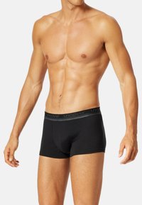 Boxer brief in cotone nero con una cintura elastica morbida che presenta il nome del marchio. Il design è aderente e leggermente più lungo nella lunghezza della gamba.