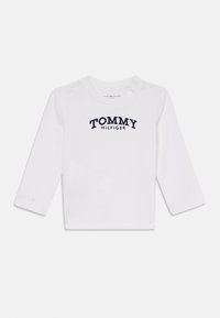 Cămașă albă cu mâneci lungi din bumbac, cu un logo în culori bleumarin "TOMMY HILFIGER" pe piept și nasturi cu capsenă pe umăr.
