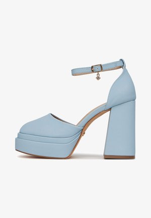 Zapato de tacón alto de plataforma azul claro con correa en el tobillo, hebilla dorada y adorno decorativo, con tacón ancho y puntera cerrada redondeada.