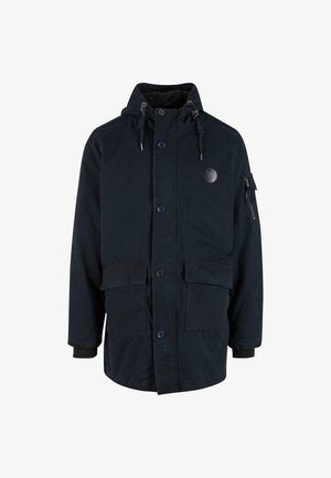 Marineblauwe, middellange parka jas met een rits- en knoopsluiting, een capuchon met trekkoord, twee voorzakken en een zak op de mouw. Zachte textuur.