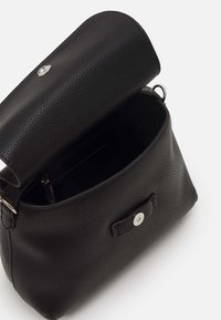 Czarna skórzana torba o fakturowanej powierzchni, cylindrycznym kształcie i srebrnym zatrzasku. Otwarta góra odsłania przestronne wnętrze.