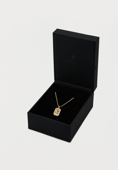 Kultainen riipuskaulakoru, jossa on kukkakuvio suorakaiteen muotoisessa koristeessa, esillä mustassa laatikossa, jossa on pehmeä sisusta. Ketju on herkkä ja ohut.