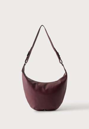 Sac à épaule en cuir bordeaux foncé avec bandoulière ajustable, fond arrondi et forme souple non structurée sur fond uni.