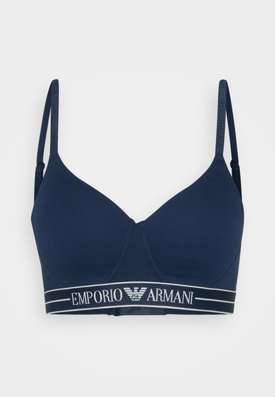 Navy blue soft bra featuring thin straps and a wide elastic band with "Emporio Armani" logo in white, smooth texture, and lightly padded cups.