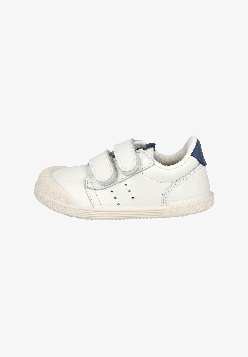 Zapatillas blancas para niños con dos correas de velcro, puntera de goma, detalles de perforación y una tab de talón azul marino.