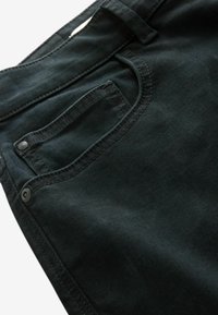Zwarte spijkerbroek van denim met een voorzak, een zichtbare knoopsluiting en subtiele stikseldetails, die een soepele textuur tonen.