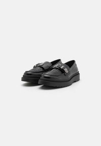 Černé kožené loafers s embosovaným designem na svršku, stříbrným kováním a silnou gumovou podrážkou, s hladkým povrchem.