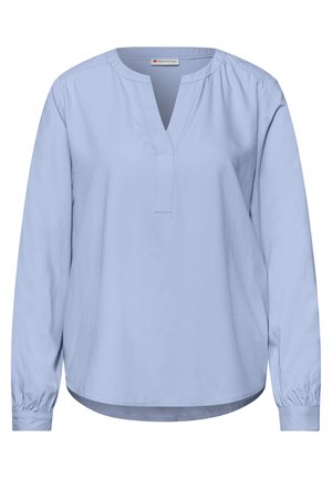 Blouse bleu clair à manches longues avec un col rond et une découpe en V au centre, dotée de poignets à boutons et d'un ourlet légèrement incurvé.