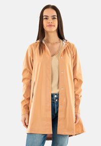 Impermeabile leggero di colore pesca realizzato in materiale impermeabile. Caratterizzato da cappuccio, chiusura a bottoni a pressione e tasche laterali.