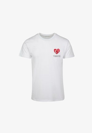 Fehér pamut póló szív grafikával, piros és fehér mintázattal, alatta a "TÜRKİYE" szó fekete betűkkel nyomtatva. Rövid ujjú.