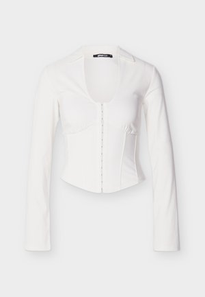 Biała dopasowana koszulowa kurtka z długimi rękawami, głębokim dekoltem w kształcie litery U na przodzie, guzikiem z przodu i konstrukcją dopasowanego gorsetu. Gładka tekstura tkaniny.