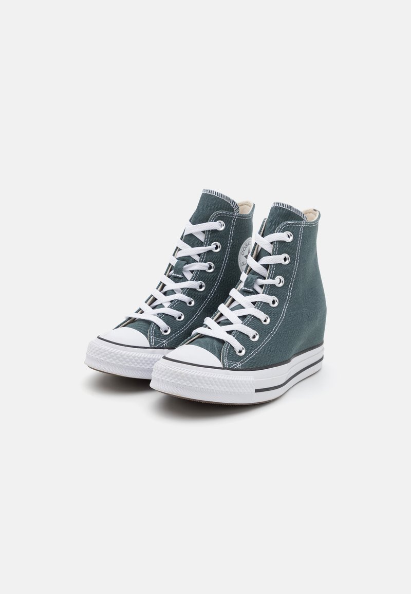 High-top sneakers in teal canvas with white laces, rubber toe cap, and striped rubber sole. Features a logo patch on the side.