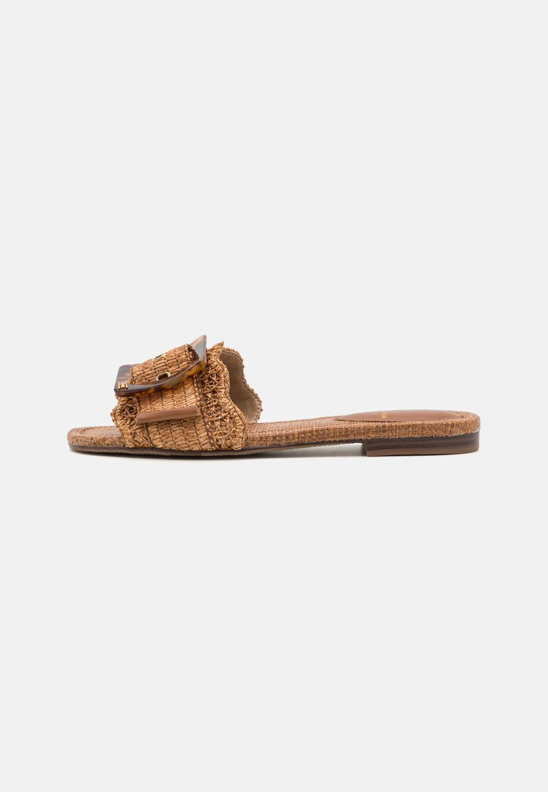 Braided tan slide sandals with a textured upper, featuring a large, glossy, rectangular hardware accent on a ruffled design. Flat sole.