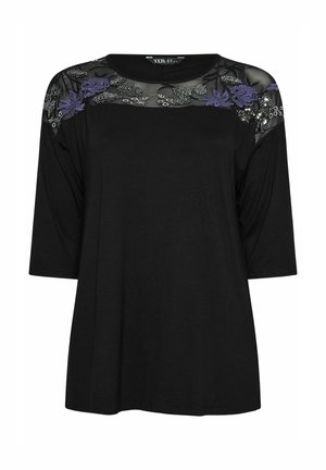 Czarny T-shirt z krótkim rękawem, z przezroczystą czarną siateczką w okolicy ramion, ozdobioną fioletowymi i srebrnymi haftami kwiatowymi. Regularny krój.