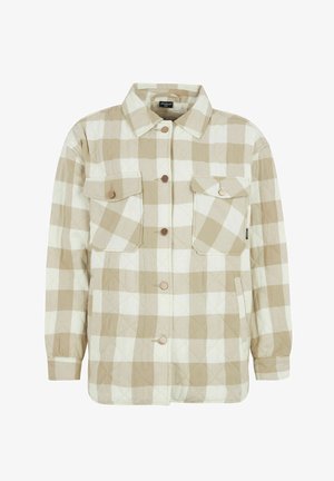 Beżowa i kremowa koszula flanelowa w kratę, z wyciąganym kołnierzem, dwiema kieszeniami na piersiach i guzikami z przodu. Wykonana z miękkiego materiału.