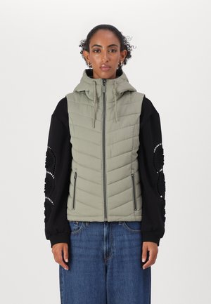 Gilet rembourré vert clair avec capuche, doté de manches longues noires ornées de motifs décoratifs et de poches latérales. Matériau textur�é sur toute la surface.
