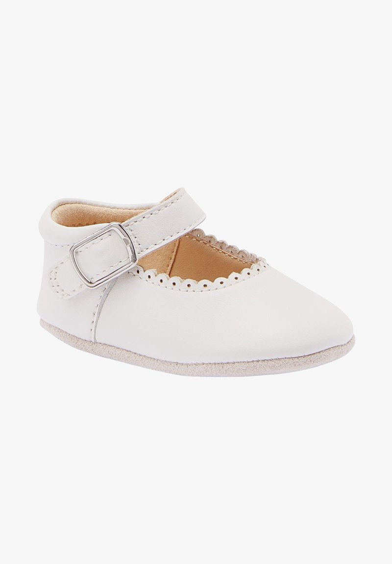 Chaussure Mary Jane en cuir blanc avec bord festonné, bride ajustable avec boucle argentée, intérieur doux couleur beige et semelle lisse.
