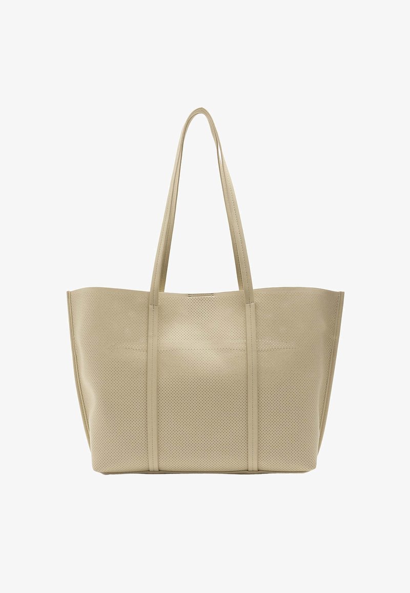 Beżowa torba tote z perforacjami i długimi uchwytami. Gładka tekstura, ustrukturyzowany kształt i minimalistyczny design. Brak widocznych elementów metalowych lub akcentów.