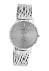 Silver stainless steel watch with a round case, mesh band, minimalist gray dial, linear hour markers, and branded ‘OOZOO’ and ‘Vintage’ text.