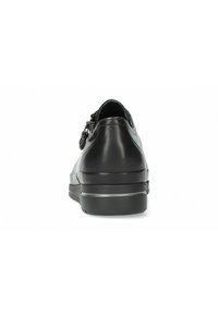 Chaussure en cuir noire avec un bout rond, semelle en caoutchouc plate et détail de fermeture éclair sur le côté. Texture lisse, matériel minimal et sans motifs visibles.
