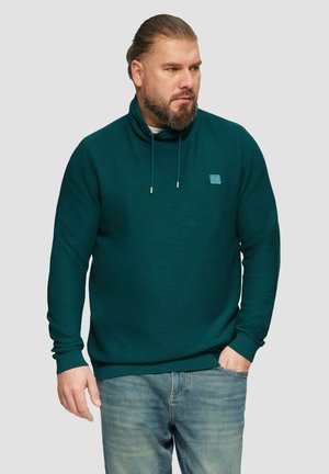Pull en maille de couleur bleu sarcelle avec un col cheminée, cordon de serrage et petit logo sur la poitrine. Texture douce et coupe décontractée.