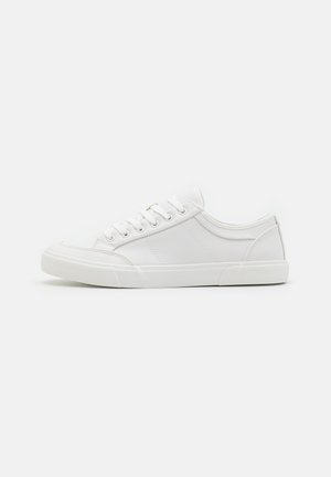 White sneakers with a smooth leather upper, round toe, flat rubber sole, and six eyelets for laces. Subtle stitching details, minimalist design.