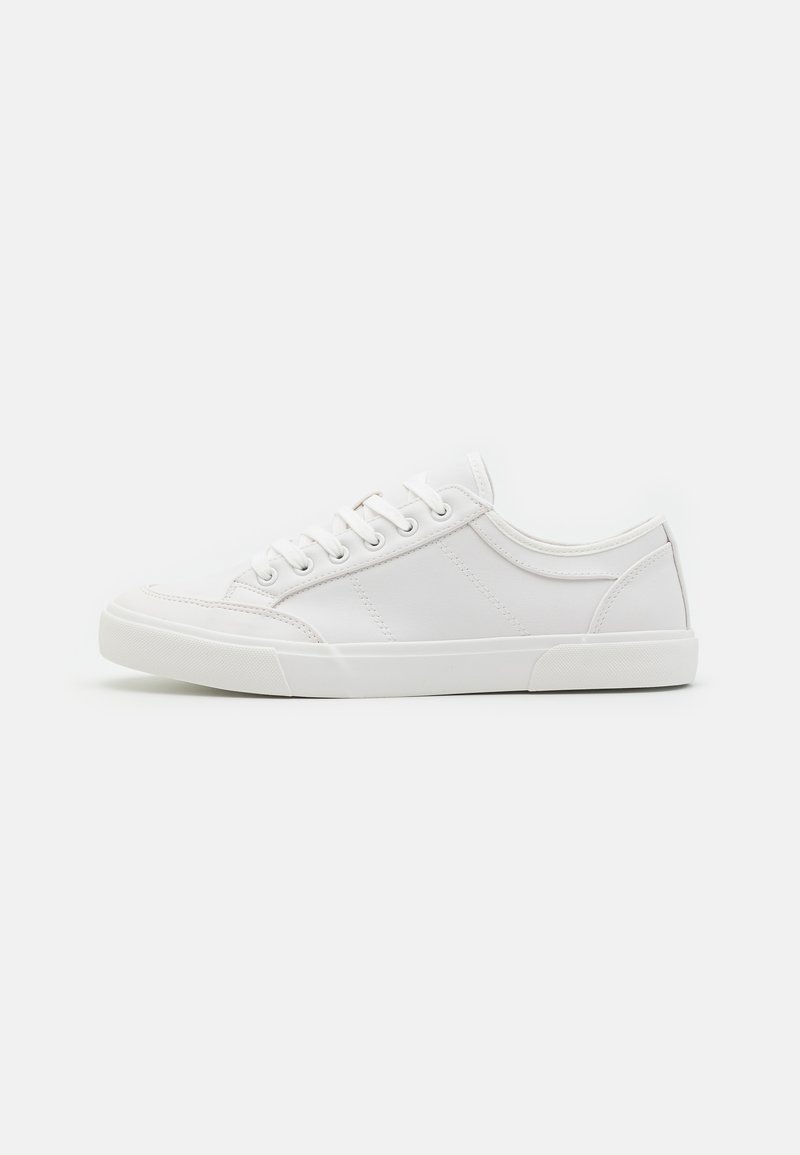 Sneakers bianchi con tomaia in pelle liscia, punta tonda, suola piatta in gomma e sei fori per i lacci. Dettagli di cucitura sottili, design minimalista.