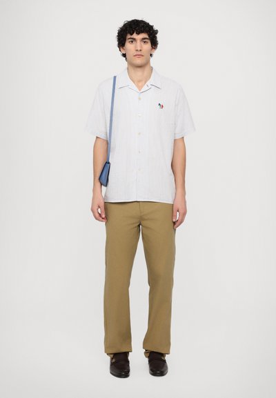 Short-sleeve striped shirt in white and blue with a button-down design, paired with khaki pants and dark brown slip-on shoes.