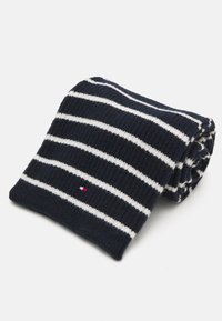 Marineblå ribbestrikket skjerf med hvite striper, som har et lite logo-patch i rødt, hvitt og blått. Rullet og pent utstilt.