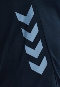 Dunkles Gewebe mit vier hellblauen Zickzackformen, die vertikal an der rechten Seite angeordnet sind.