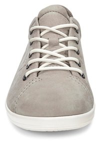 Lys grå suede sneakers med hvite snørebånd, svarte øyelets og en hvit gummisåle. Har subtile sømdetaljer på overdelen.