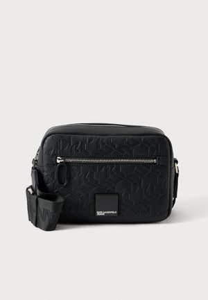 Sac bandoulière rectangulaire noir avec motif embossé, poche avant zippée, bandoulière ajustable et petite étiquette logo Karl Lagerfeld Jeans.