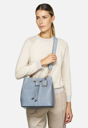 Borsa a secchiello in pelle azzurro chiaro con chiusura a cordoncino, dettagli in metallo dorato e tracolla rimovibile. Finitura testurizzata e piccolo dettaglio con etichetta.