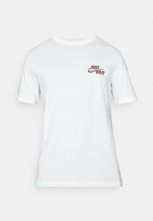 Tricou alb cu mânecă scurtă din bumbac, având un mic logo roșu „Just Do It” în zona stângă a pieptului. Design simplu cu guler rotund.