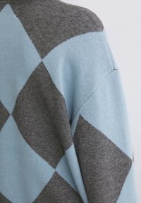 Grau und hellblaues Argyle-Muster auf einem weichen Strickpullover, mit lockerer Passform und Raglanärmeln sowie einer glatten Textur.