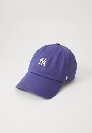Fioletowa czapka z daszkiem z białym haftowanym logo New York Yankees na przodzie oraz małym logo marki po boku.