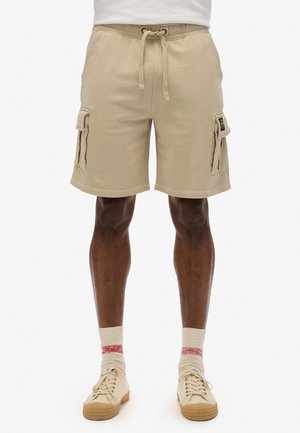 Beige cargo shorts med elastisk talje og snøre, med sidelommer og en afslappet pasform. Lavet af blødt stof, knælange.