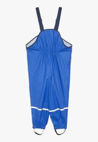 Μπλέ αδιάβροχα παντελόνια με ρυθμιζόμενες ναυτικές τιράντες, ελαστική μέση και λευκή ανακλαστική ταινία στη μέση του μοσχάριου. Ελαστικές μανσέτες στους αστραγάλους.