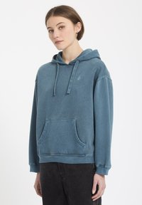 Blauwe katoenen hoodie met een voorzak, een verstelbare capuchon met trekkoord, ribbelmanchetten en een ribbelrand. Bevat een klein logo op de borst.