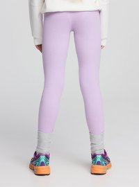 Leggings aderenti color lavanda con polsini grigi alla caviglia, abbinati a scarpe da ginnastica multicolori con suola testurizzata e design colorato.