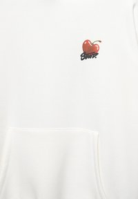 Felpa bianca con cappuccio caratterizzata da una piccola grafica di ciliegia rossa con un gambo verde e testo nero sottostante. Tessuto di cotone morbido, tasca frontale.