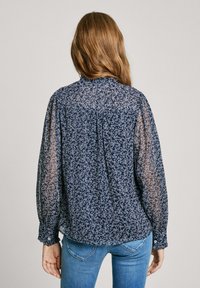 Navyblaue Bluse mit floralem Muster, durchsichtigen langen Ärmeln, gerafftem Rücken und geknöpften Manschetten. Leichtes Material.