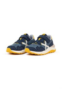 Sneakers sportivi blu con suole gialle. Presentano una parte superiore testurizzata, una cinghia regolabile e un design a strisce bianche in contrasto.
