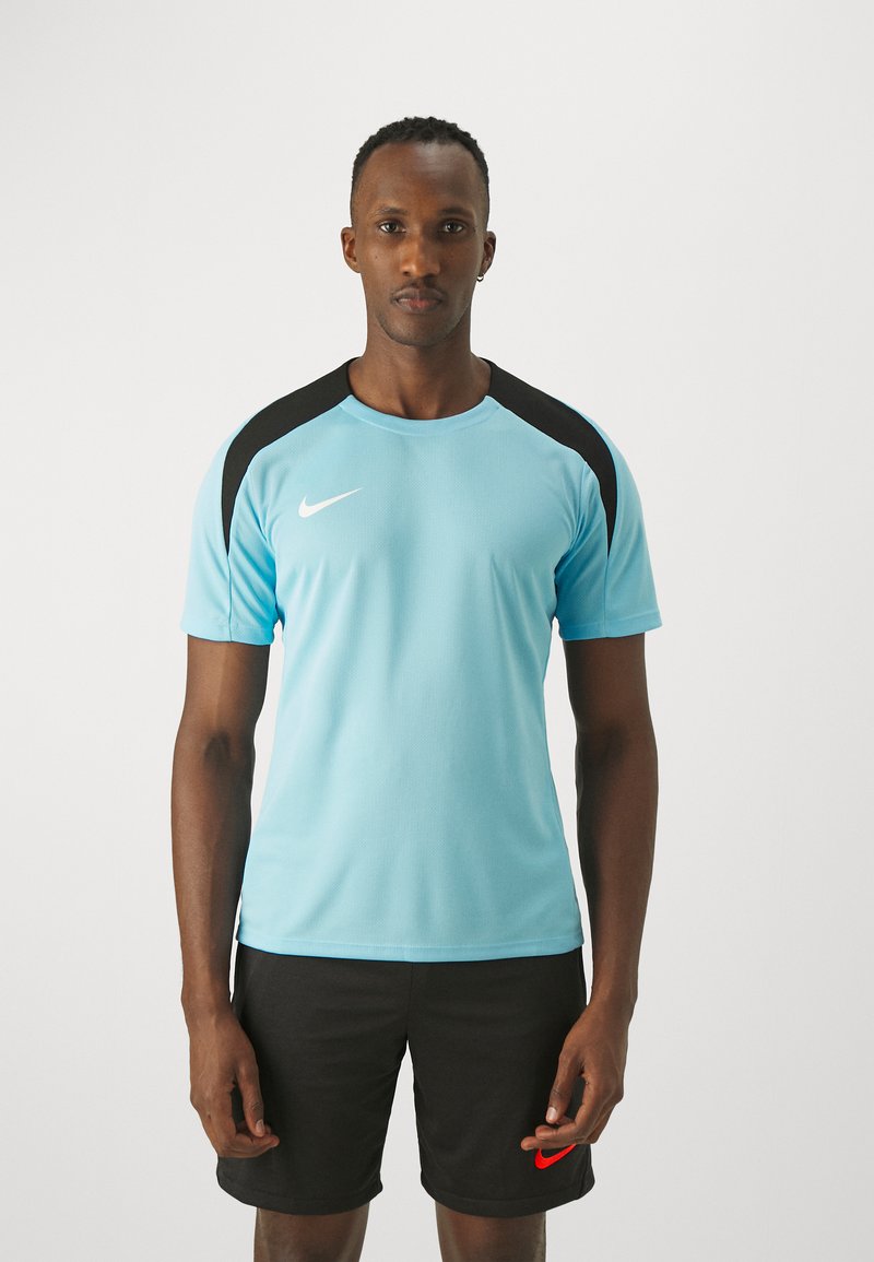 Jersey deportivo de Nike de tela azul claro con acentos negros en los hombros, combinado con pantalones cortos negros que presentan un logotipo rojo.