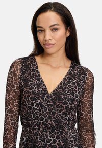 Leopardenmuster Wickelkleid mit langen transparenten Ärmeln, das eine tiefe V-Ausschnitt und eine taillierte Taille für eine figurbetonte Silhouette aufweist.