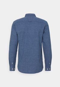 Donkerblauwe blouse met lange mouwen in een gevarieerde stof. Voorzien van een kraag, knopen bij de manchetten en een ronde zoom aan de onderkant.