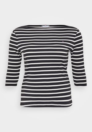 Czarna i biała w paski koszula z długim rękawem, o dekolcie w łódkę i małym logo na piersi, wykonana z materiału prążkowanego.